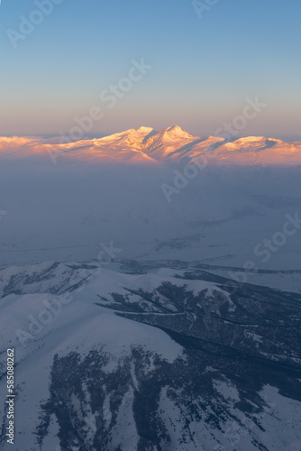 Aerial high altitude view of Mount Aragats highest mountain in Armenia lit by rising sun  Caucasus
