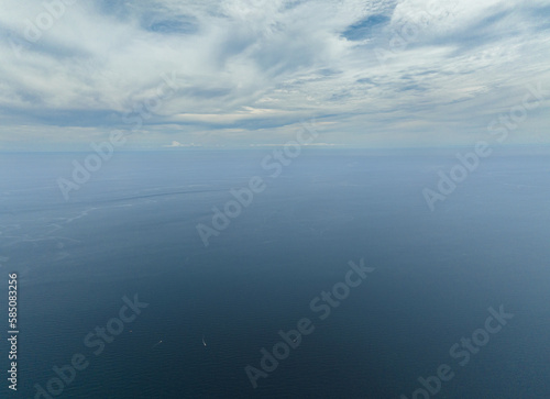 Aerial view of blue ocean with waves and blue sky with cloud, aerial view. Water cloud horizon background.