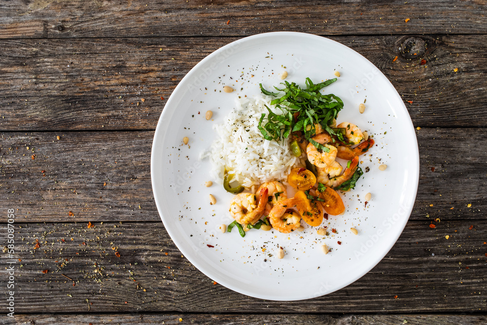 Fried prawns with boiled white rice, mini yellow tomatoes on wooden table Fried prawns with boiled white rice, mini yellow tomatoes on wooden table