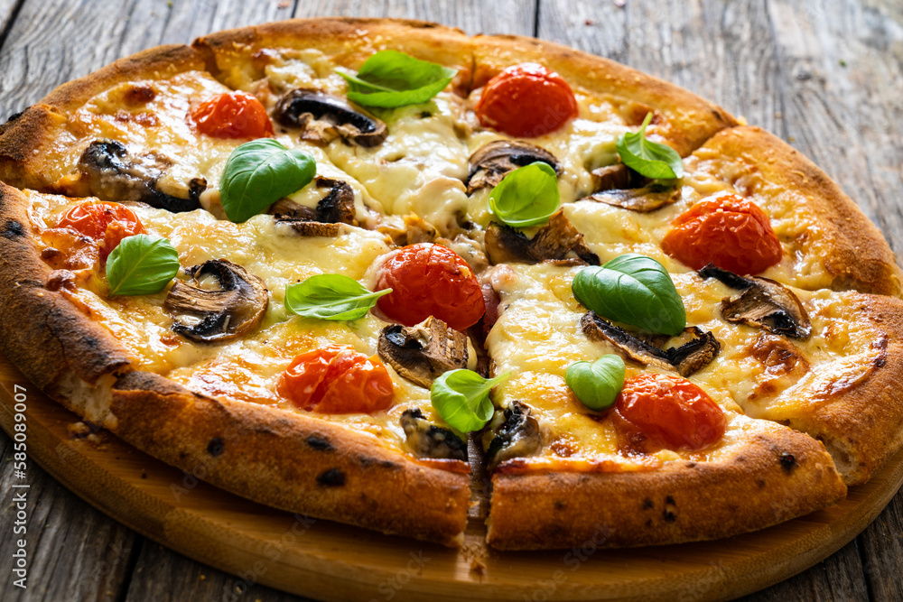 Circle vegetarian pizza with mozzarella cheese, mushrooms and tomatoes on wooden table
Circle vegetarian pizza with mozzarella cheese, mushrooms and tomatoes on wooden table