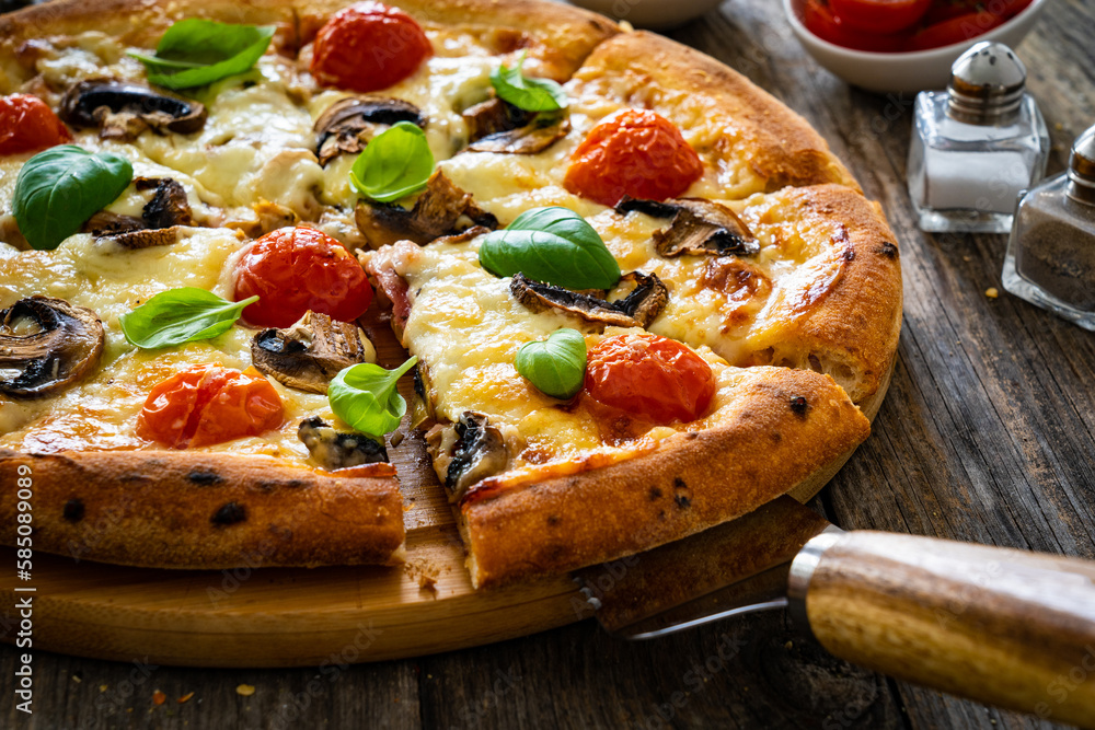 Circle vegetarian pizza with mozzarella cheese, mushrooms and tomatoes on wooden table
Circle vegetarian pizza with mozzarella cheese, mushrooms and tomatoes on wooden table