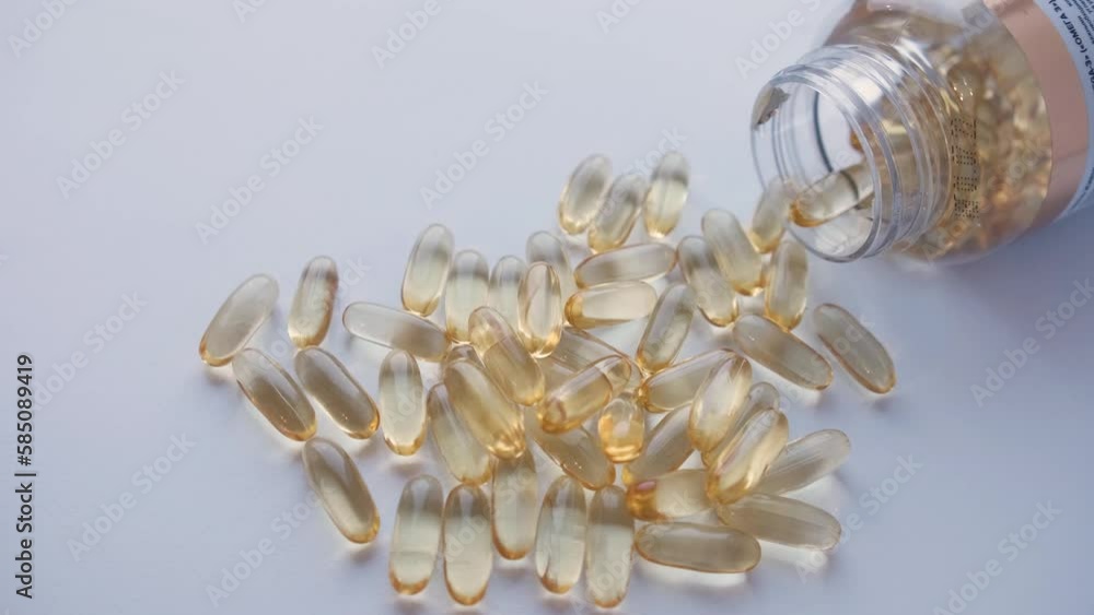 Omega Cod Cod liver oil omega 3 gel capsules spilling out of a bottle. Stock 비디오 ...