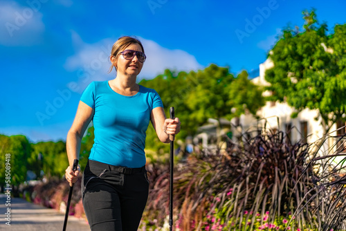Nordic walking - woman training in city park 