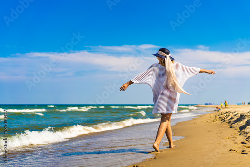Woman walking on sunny beach 