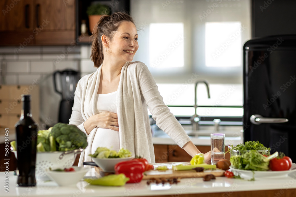 Pregnant woman prepare healthy food in the kitchen and feel so happy