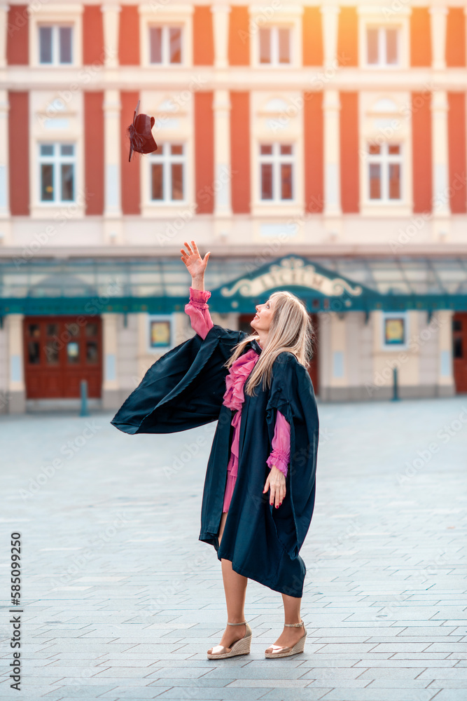 forty-year-old happy woman in a graduation gown walking around the city center.  Study at any age