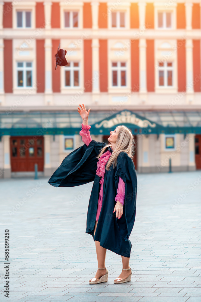 forty-year-old happy woman in a graduation gown walking around the city center. Study at any age forty-year-old happy woman in a graduation gown walking around the city center. Study at any age