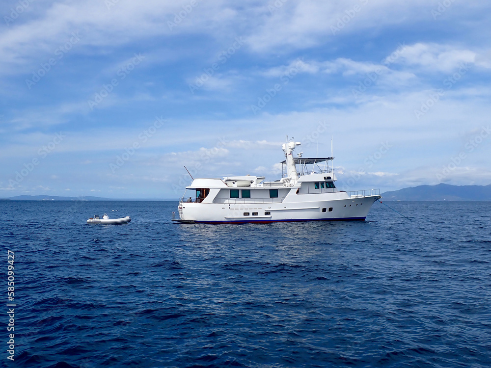 Motor yacht. Cruise ship. Safari Dive Boat. Luxury white motor yacht and small inflatable motorboat on the open sea. Motor yacht. Cruise ship. Safari Dive Boat. Luxury white motor yacht and small inflatable motorboat on the open sea.