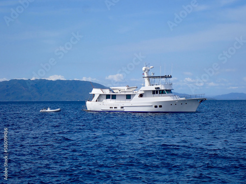 Motor yacht. Cruise ship. Safari Dive Boat. Luxury white motor yacht and small inflatable motorboat on the open sea. © Houston
