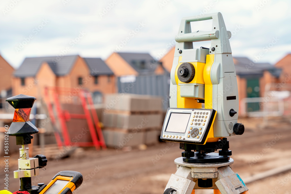 Surveyor builder site engineer with theodolite total station at construction site outdoors during surveying work Surveyor builder site engineer with theodolite total station at construction site outdoors during surveying work