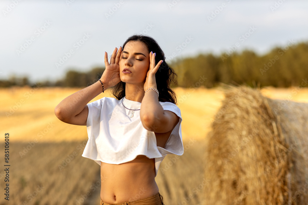 Young beautiful woman in rural agriculture field of harvest straw Young beautiful woman in rural agriculture field of harvest straw
