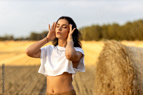 Photographie Young beautiful woman in rural agriculture field of harvest straw