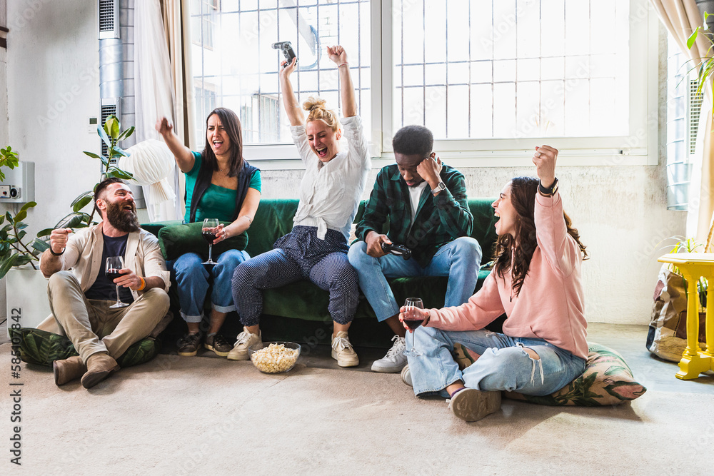 Fototapeta premium Young friends having fun and cheering with video games