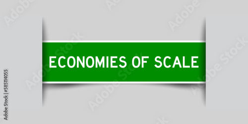 Inserted green color label sticker with word economies of scale on gray background