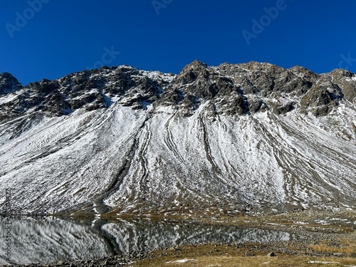 First snow on the rocky mountain peak Chlein Schwarzhorn (2967 m) in the Albula Alps and above the Swiss mountain road pass Fluela (Flüelapass), Davos - Canton of Grisons, Switzerland (Schweiz) photo