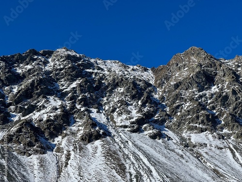 First snow on the rocky mountain peak Chlein Schwarzhorn (2967 m) in the Albula Alps and above the Swiss mountain road pass Fluela (Flüelapass), Davos - Canton of Grisons, Switzerland (Schweiz) photo