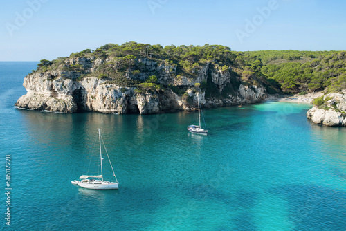 Beautiful beach with sailing boat yacht, Menorca island, Spain. Sailing boats in a bay. Summer fun, enjoying life, yachting, travel and active lifestyle concept photo
