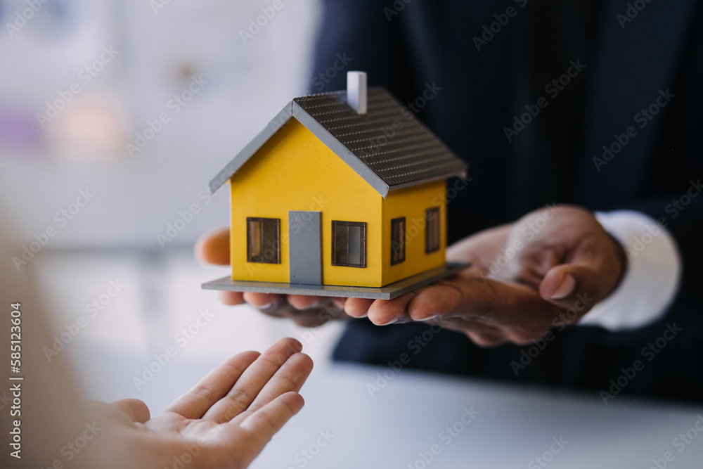House model with real estate agent and customer discussing for contract to buy house, insurance or loan real estate background. House model with real estate agent and customer discussing for contract to buy house, insurance or loan real estate background.