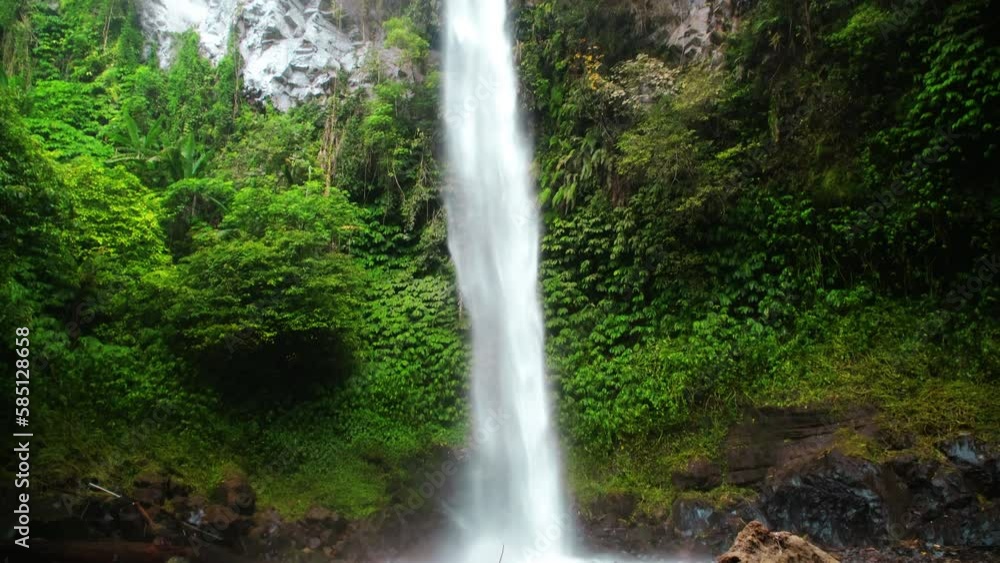 The high Blamantung waterfall, with water falling down in the wild nature. Rain forest with green plants and trees. The high Blamantung waterfall, with water falling down in the wild nature. Rain forest with green plants and trees.