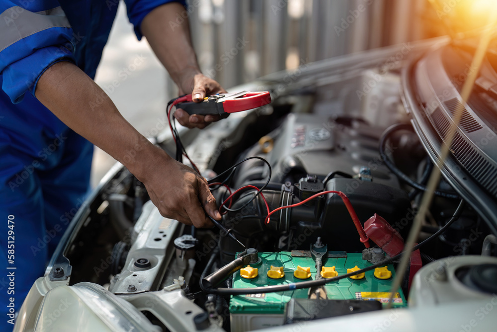 Close up technician uses multimeter voltmeter to check voltage level in car battery. Service and Maintenance car battery. Close up technician uses multimeter voltmeter to check voltage level in car battery. Service and Maintenance car battery.