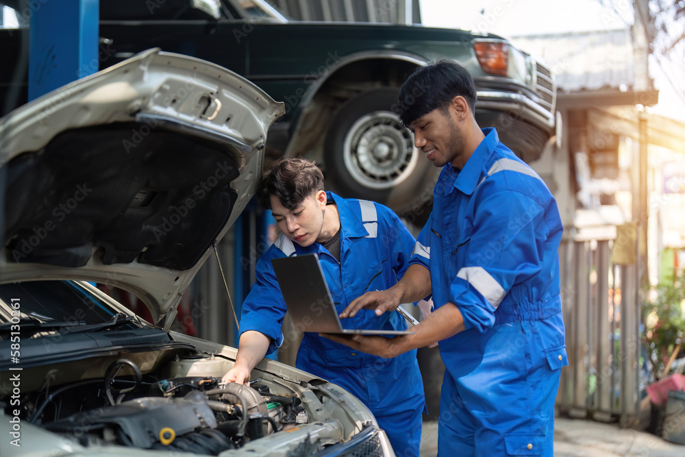 Mechanic man shows report to the asian coworker at garage, A man mechanic and his son discussing repairs done vehicle. Changing automobile business. Mechanic man shows report to the asian coworker at garage, A man mechanic and his son discussing repairs done vehicle. Changing automobile business.