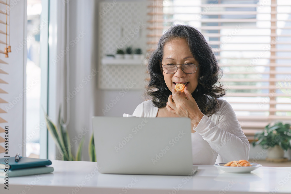 Capturing the Joys of Aging: A Happy Senior Woman Embracing Technology as She Navigates Her laptop computer with Ease from the Comfort of Her Home. Capturing the Joys of Aging: A Happy Senior Woman Embracing Technology as She Navigates Her laptop computer with Ease from the Comfort of Her Home.