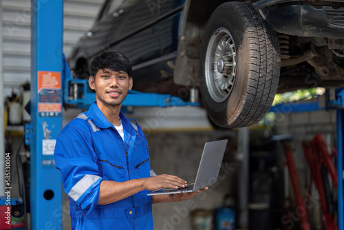 portrait of positive asian auto mechanic in uniform posing after work, he is keen on repairing cars, automobiles