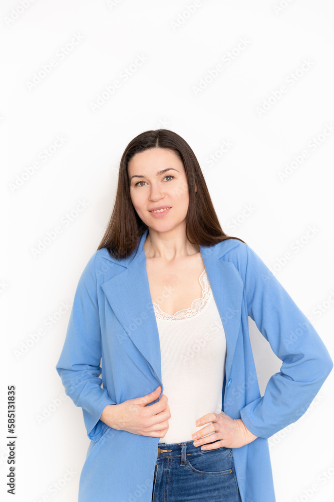 Forty year old in a blue jacket on a white background. Middle aged woman looks younger and very professional. Entrepreneur is active on social media. Forty year old in a blue jacket on a white background. Middle aged woman looks younger and very professional. Entrepreneur is active on social media.