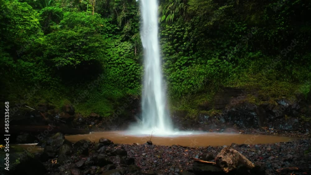The high Blamantung waterfall, with water falling down in the wild nature. Rain forest with green plants and trees. The high Blamantung waterfall, with water falling down in the wild nature. Rain forest with green plants and trees.