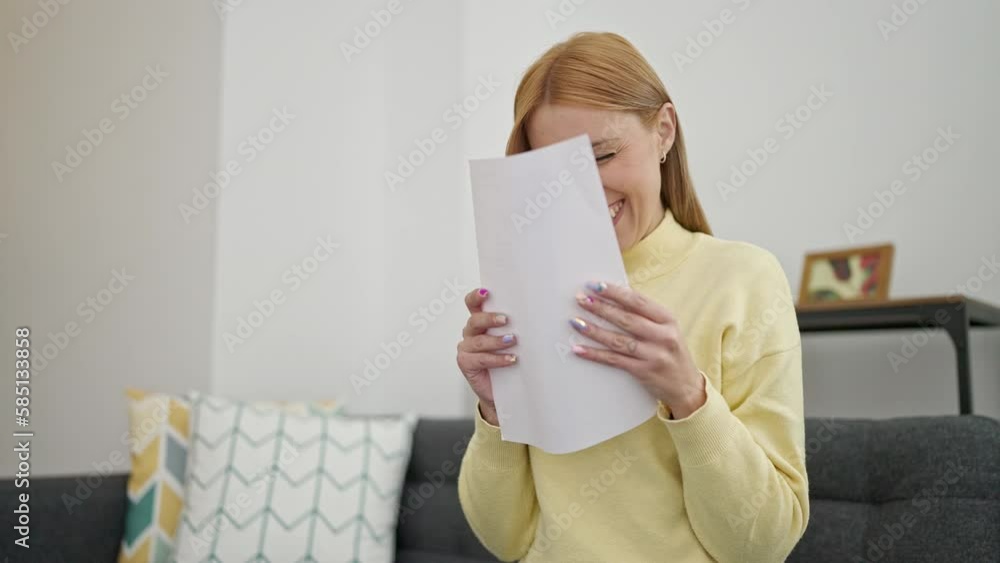 Young blonde woman reading document sitting on sofa at home Young blonde woman reading document sitting on sofa at home