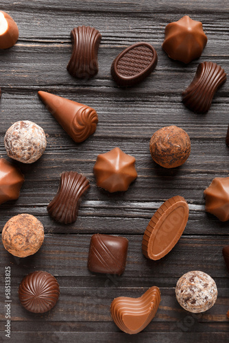 Assorted chocolates on dark wooden background top view