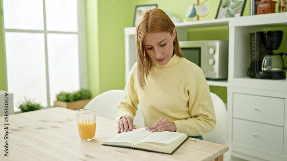 Young blonde woman reading book drinking orange juice at home Young blonde woman reading book drinking orange juice at home