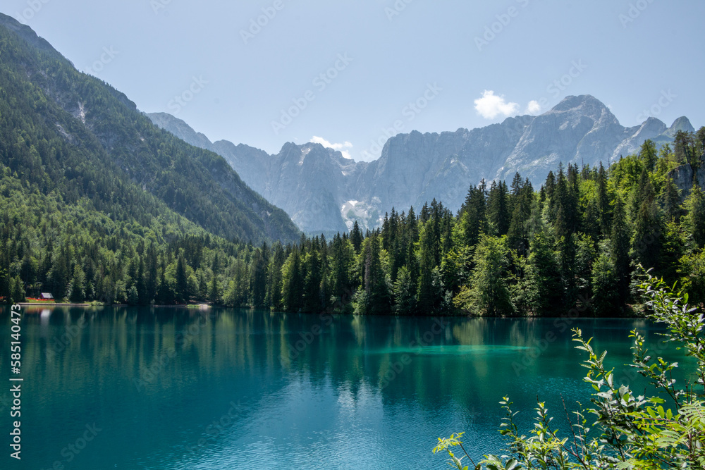 View of Lago Inferiore die Fusine in the Julian Alps of northeastern Italy with the dramatic rock face of Mount Mangart in the background