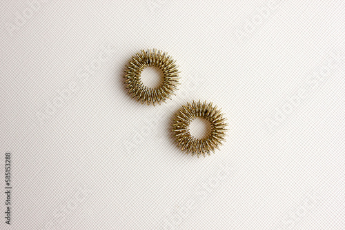 Prickly metal rings for acupressure finger insulated on a light background. .healing of the body, acupressure. Massage of hands and feet.