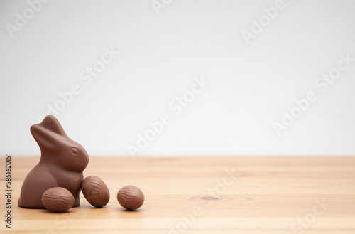 Chocolate bunny and chocolate eggs on a wooden table. Easter background.