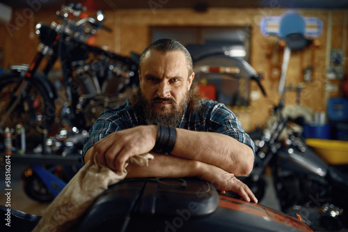 Portrait of mature biker man over his motorbike metal horse