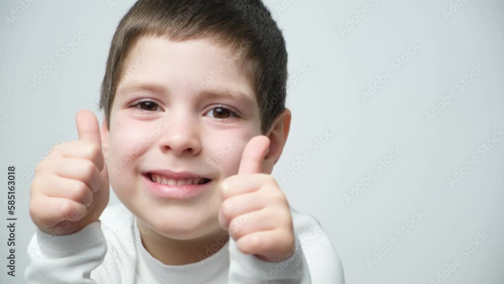 Portrait of a 5-year-old boy who points his fingers up and talks on a white background Portrait of a 5-year-old boy who points his fingers up and talks on a white background