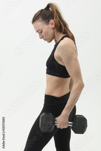 young athletic woman holding huge dumbbell isolated on white background