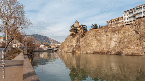 Metekhi church and Houses on the edge of a cliff above the river Kura photo