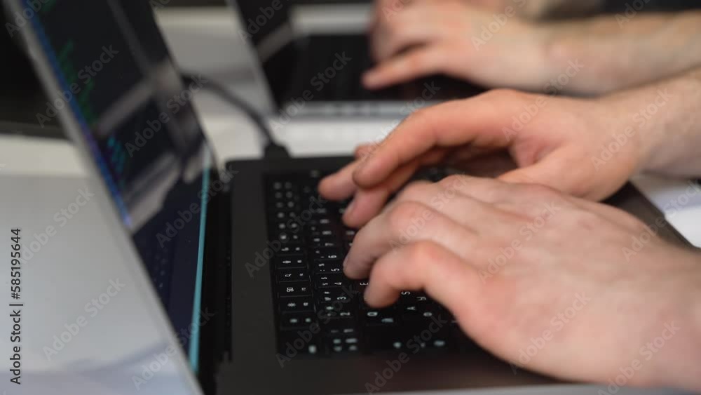 The hands of two people typing on the laptop keyboard The hands of two people typing on the laptop keyboard