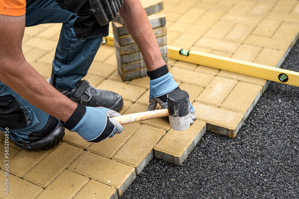 Leveling the block using a rubber hammer and spirit level. Laying of the interlocking paving. Leveling the block using a rubber hammer and spirit level. Laying of the interlocking paving.