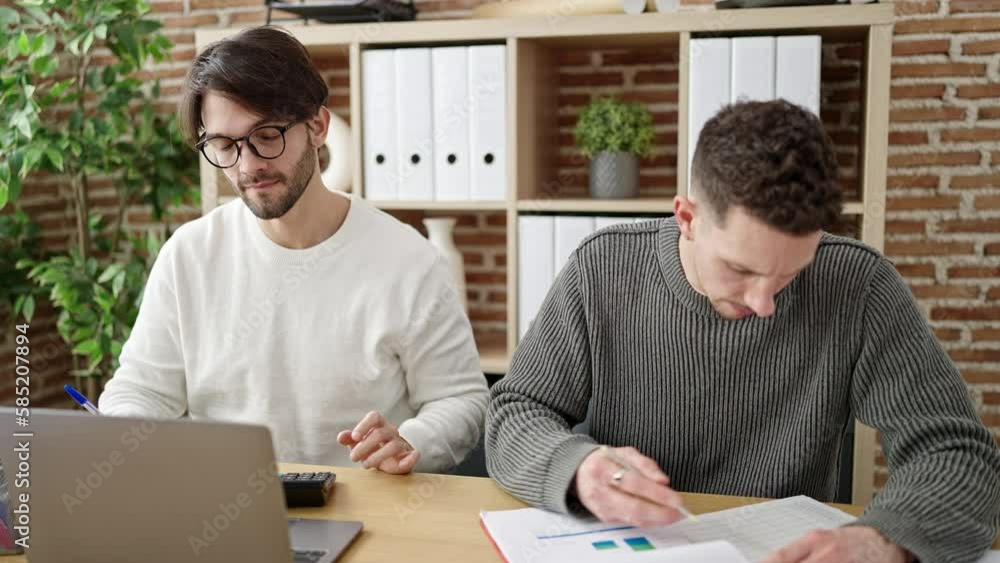 Two men business partners using laptop accounting at office Two men business partners using laptop accounting at office