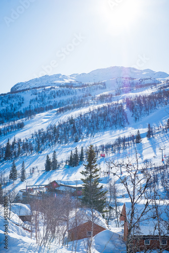 View over ski resort with slopes, chair lifts and majestic snowy mountains during winter day. Hemsedal ski center in Norway.