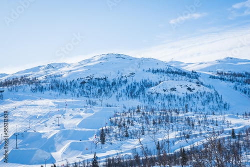 Foto View over ski resort with slopes, chair lifts and majestic snowy mountains during winter day