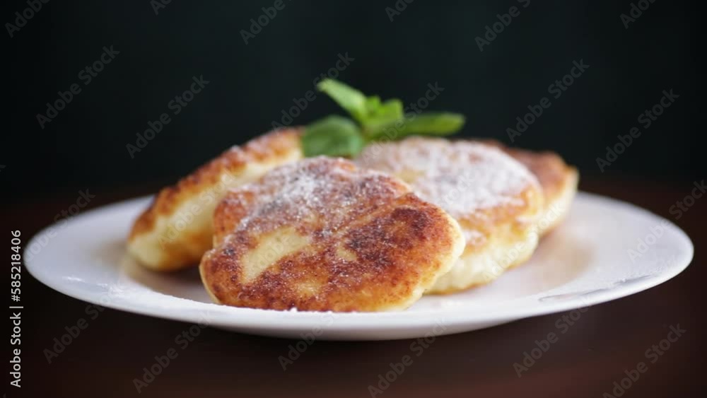 Sweet cooked cheesecakes in powdered sugar in a plate Sweet cooked cheesecakes in powdered sugar in a plate