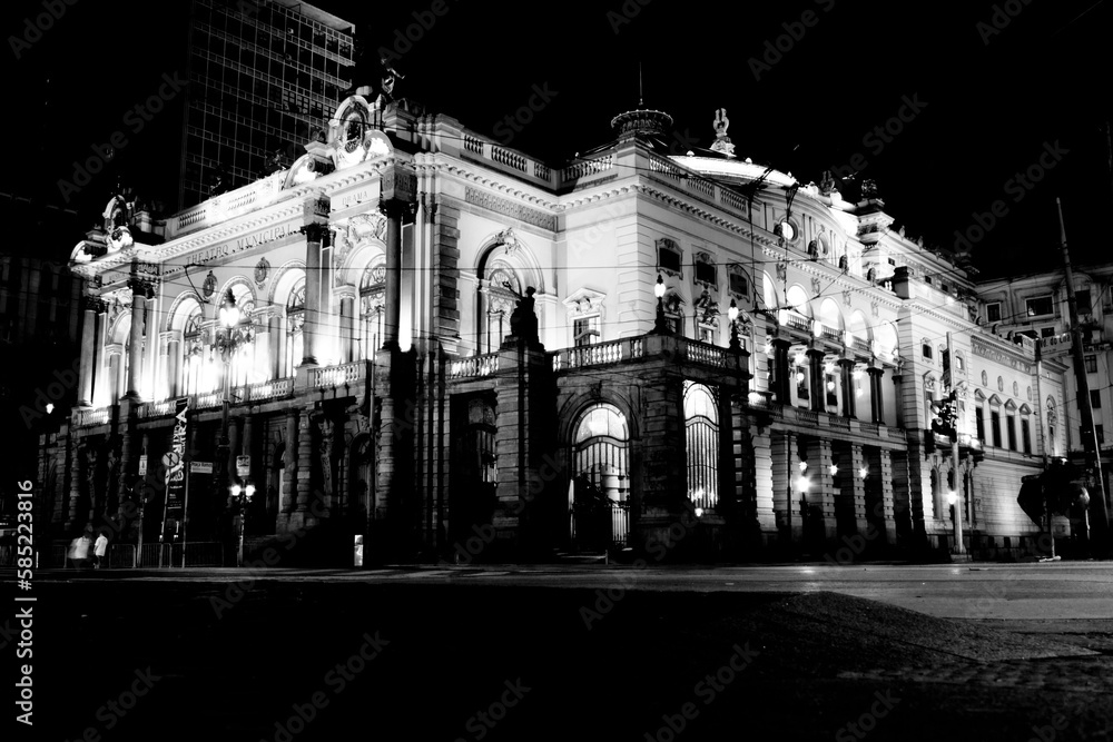 Prédio do teatro Municipal de São Paulo, a noite com rastros de luz dos carros em movimento. 