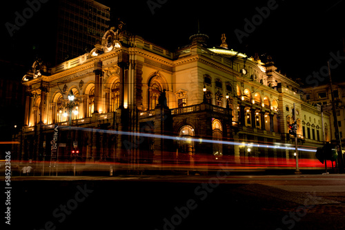 Prédio do teatro Municipal de São Paulo, a noite com rastros de luz dos carros em movimento. 