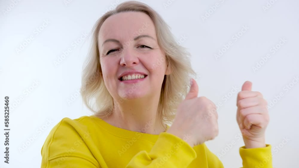 Business woman showing thumbs up on grey background. Close up of happy businesswoman twinkling eye in studio. Female professional success sign. Happy worker showing thumb up heart hands High quality Business woman showing thumbs up on grey background. Close up of happy businesswoman twinkling eye in studio. Female professional success sign. Happy worker showing thumb up heart hands High quality