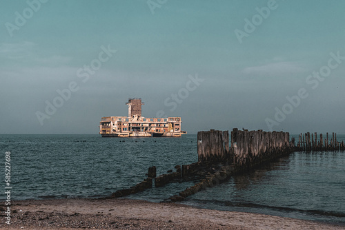 Old ruined wooden pier and a sandy beach