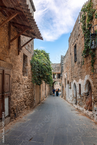 Fototapeta Naklejka Na Ścianę i Meble -  Street view of old town of Rhodes, Greece. Paved roads and pavements with colorful houses and fragrant flowers.